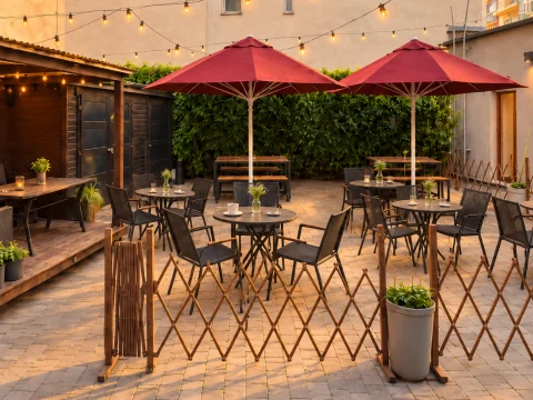 Zahrádka kavárny s červenými slunečníky a bistro stolky v teplém podvečerním světle